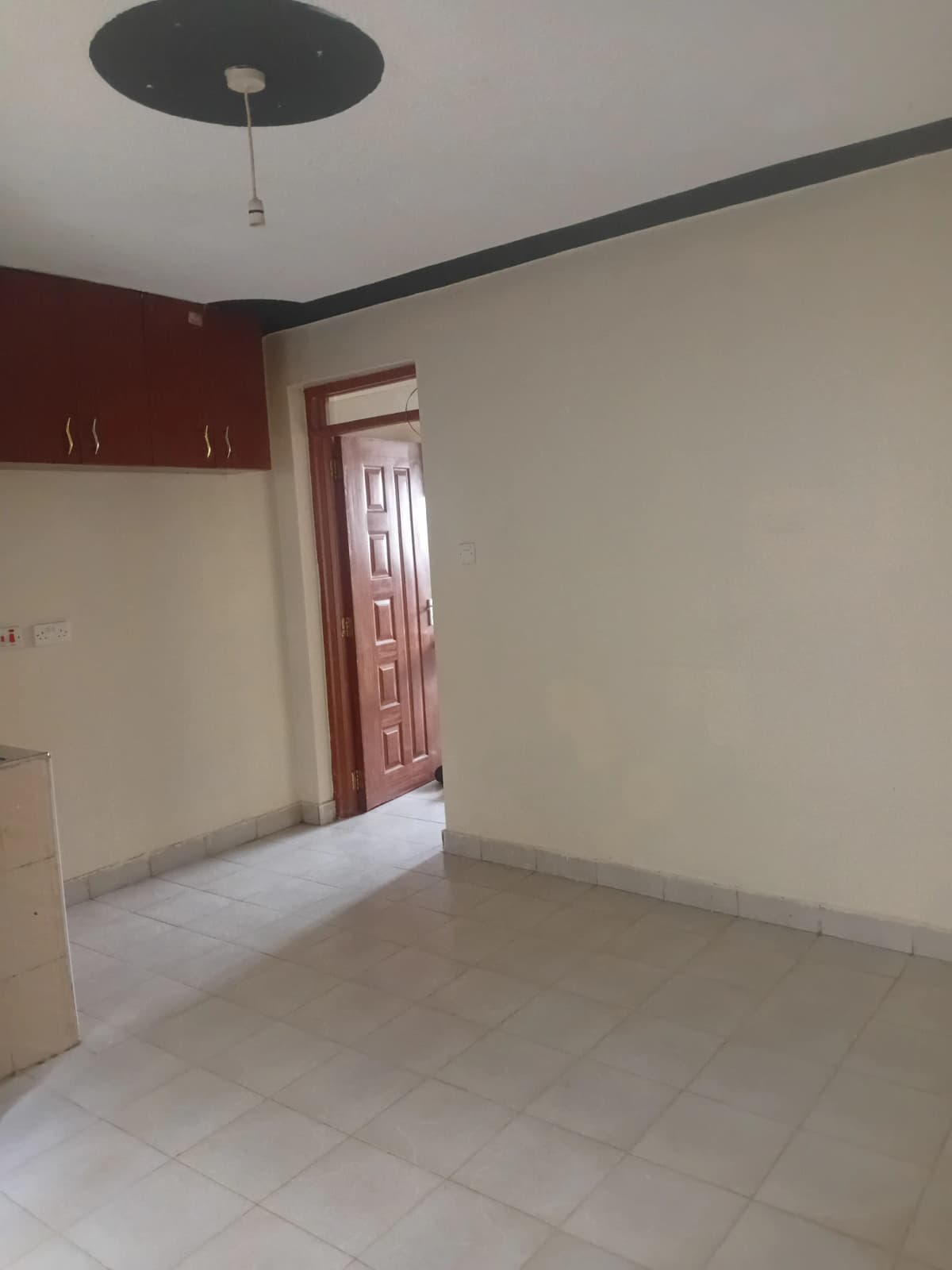 Open-plan living area with kitchen cabinetry visible in corner