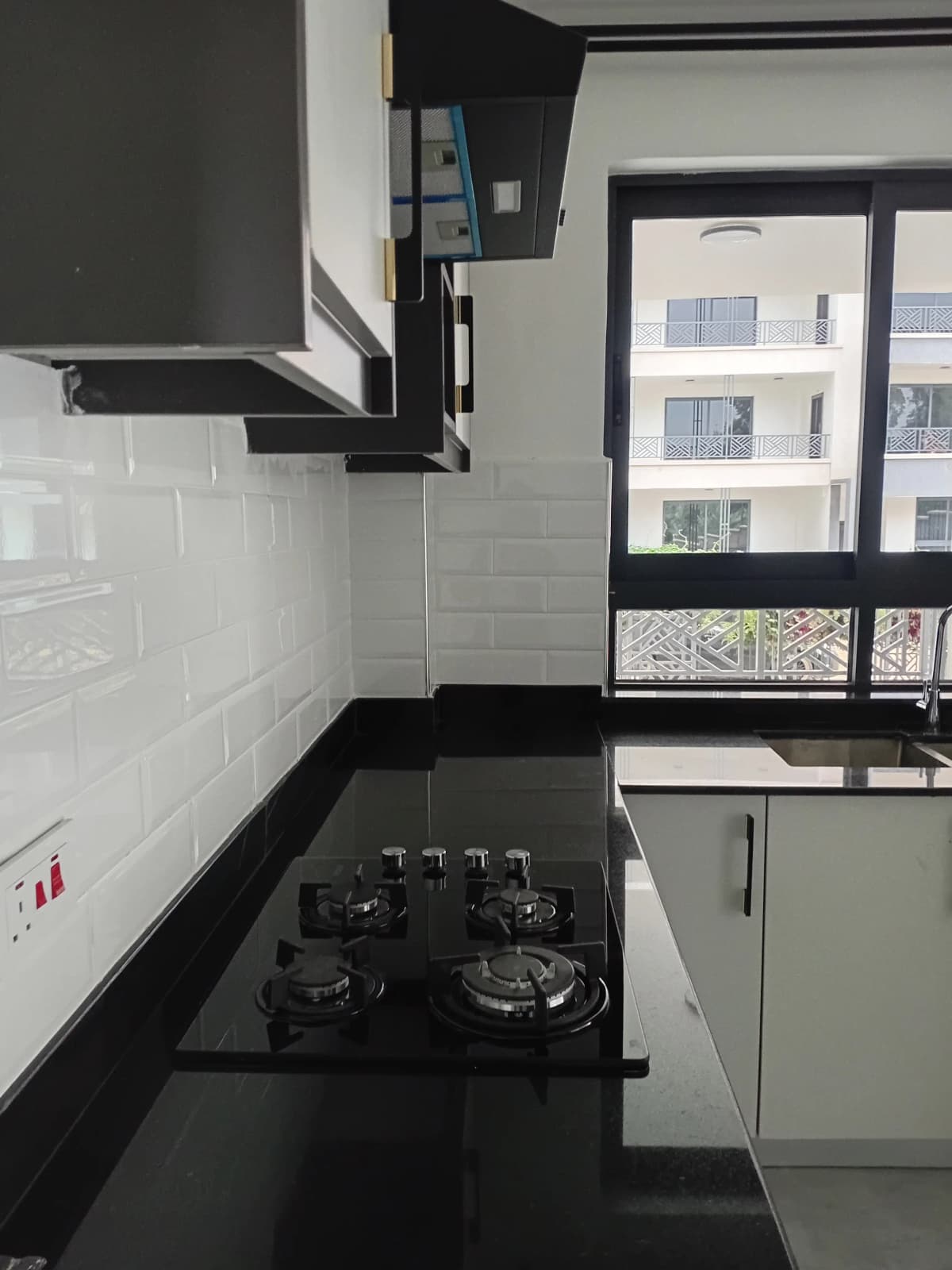 Modern kitchen with black gas cooktop and white subway tile