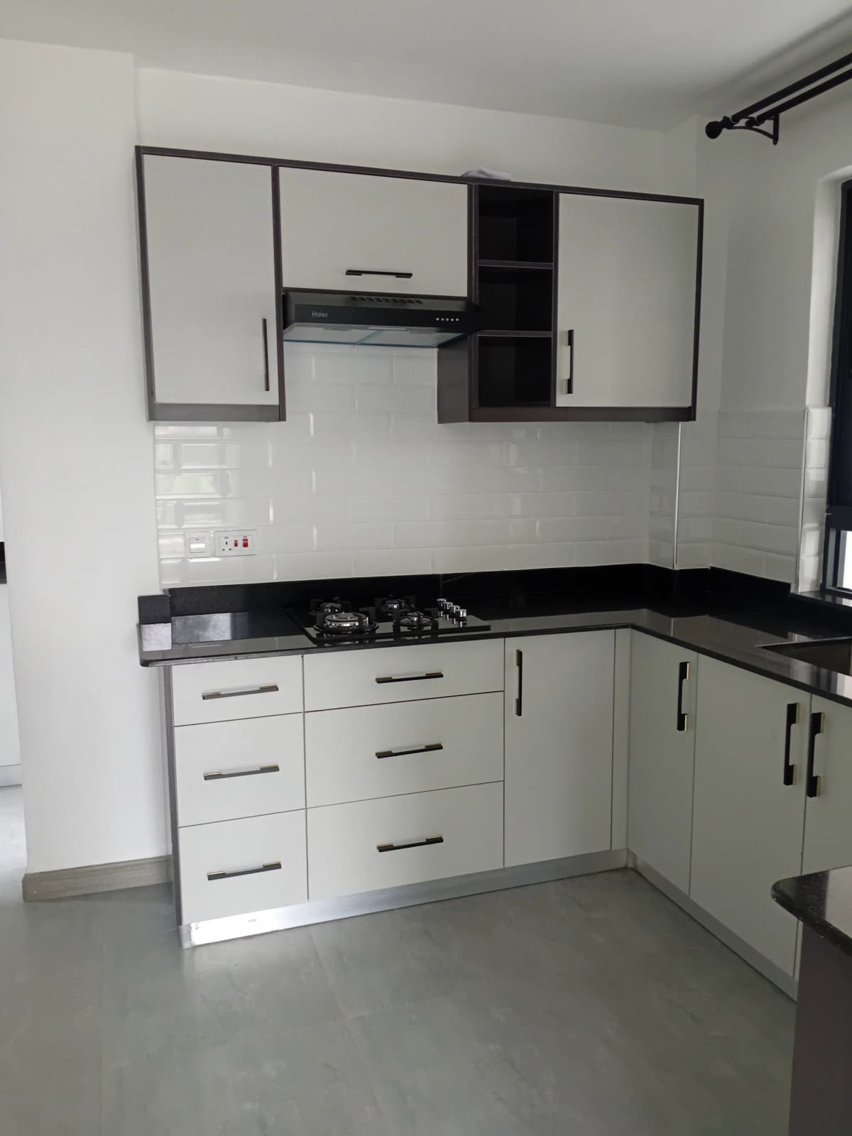 Modern L-shaped kitchen with black granite countertop and white cabinetry