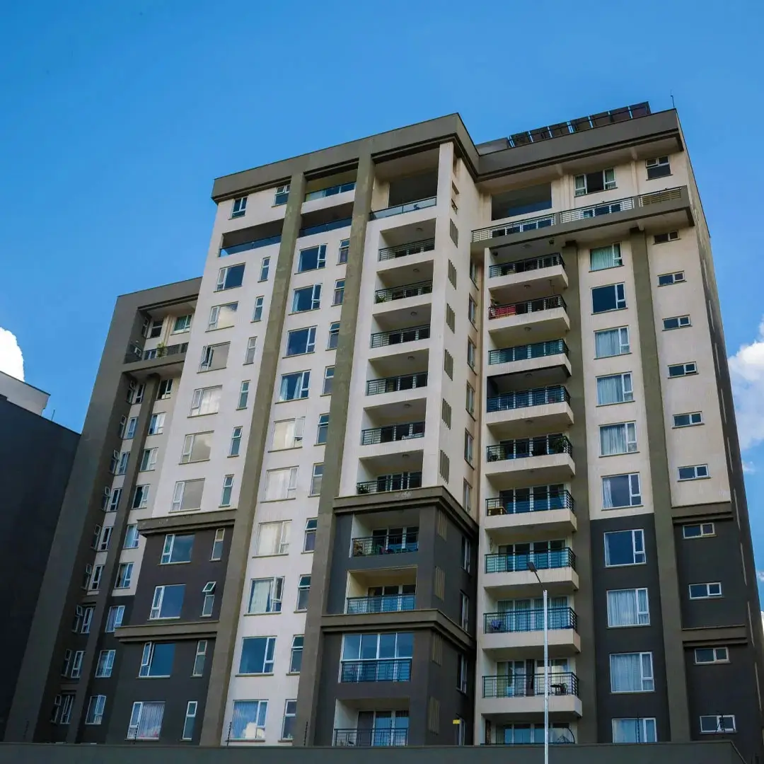 Modern multi-story residential building with balconies and blue accents