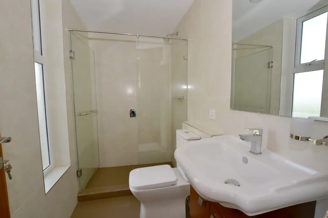 Modern bathroom with shower enclosure, toilet, and pedestal sink