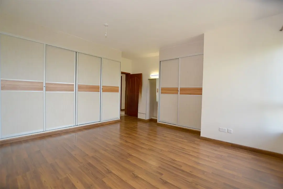 Spacious bedroom with built-in wardrobes and wooden flooring