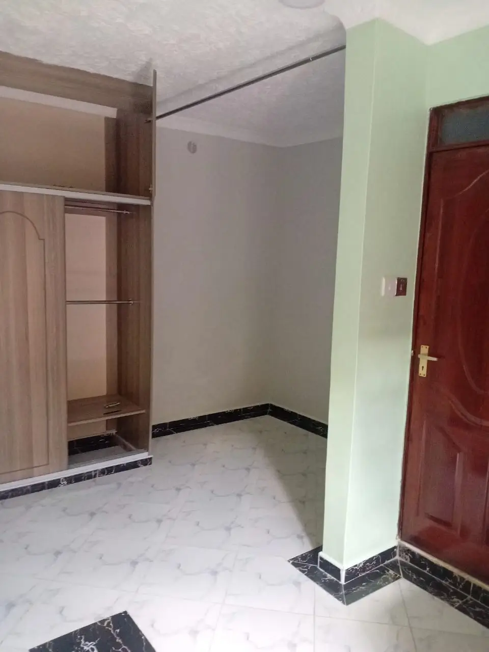 Unfurnished bedroom with built-in wardrobe and tiled flooring