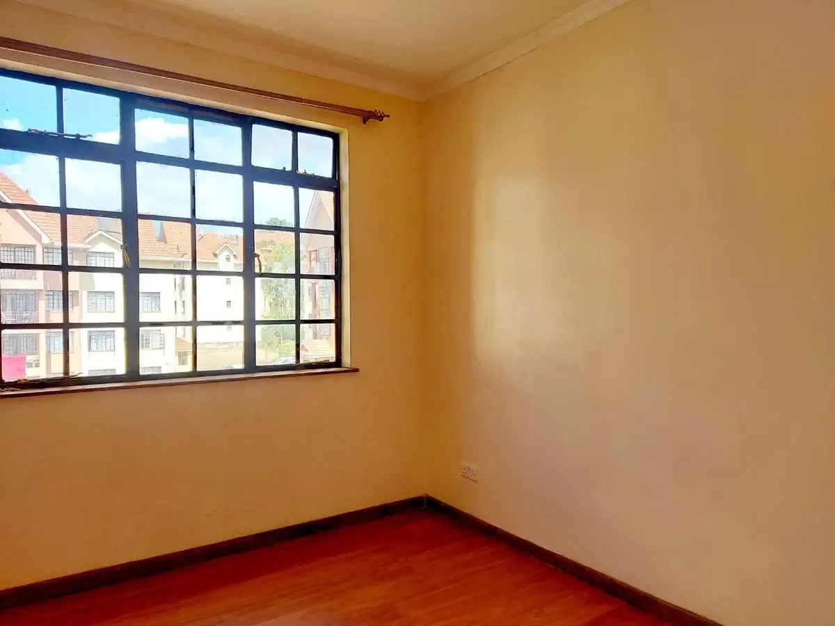 Bright bedroom with large window and red polished floor