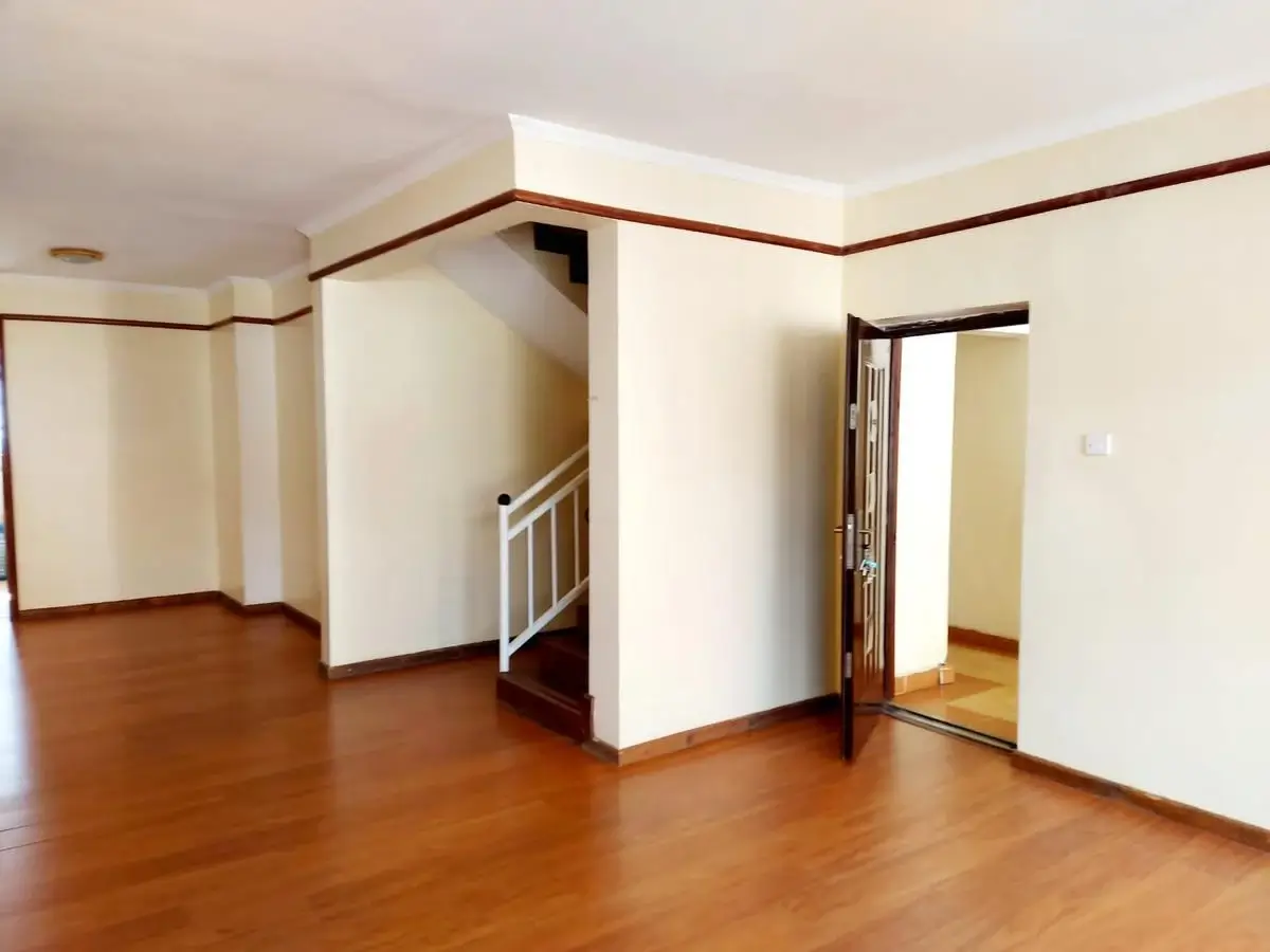 Spacious open-plan living area with wooden flooring and high ceilings