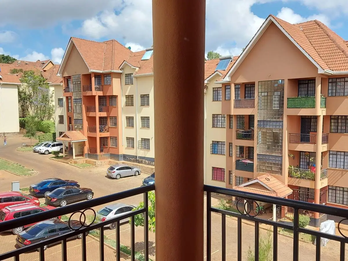Balcony overlooking residential compound with parked cars