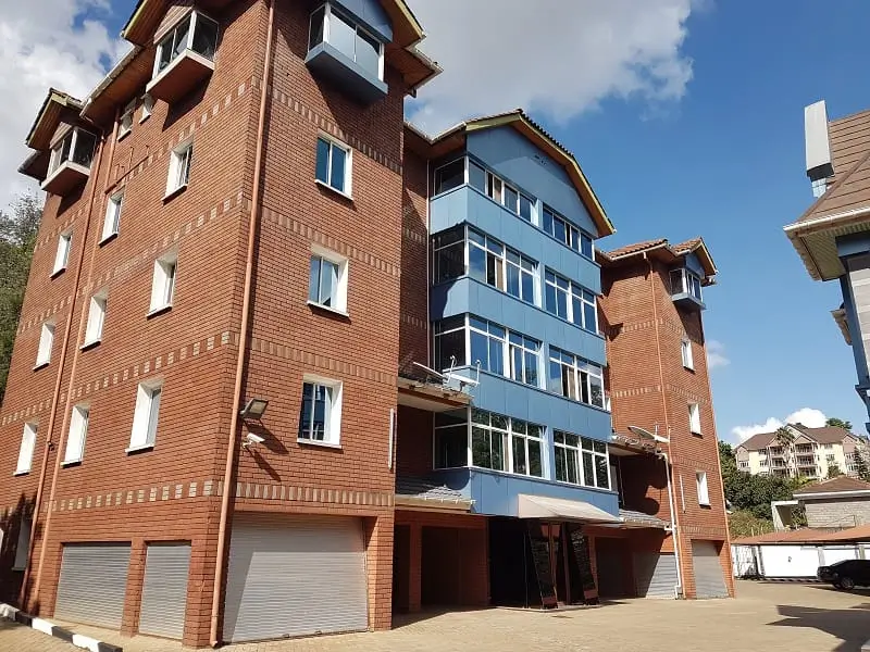 Multi-story brick apartment building with ground-floor parking garage