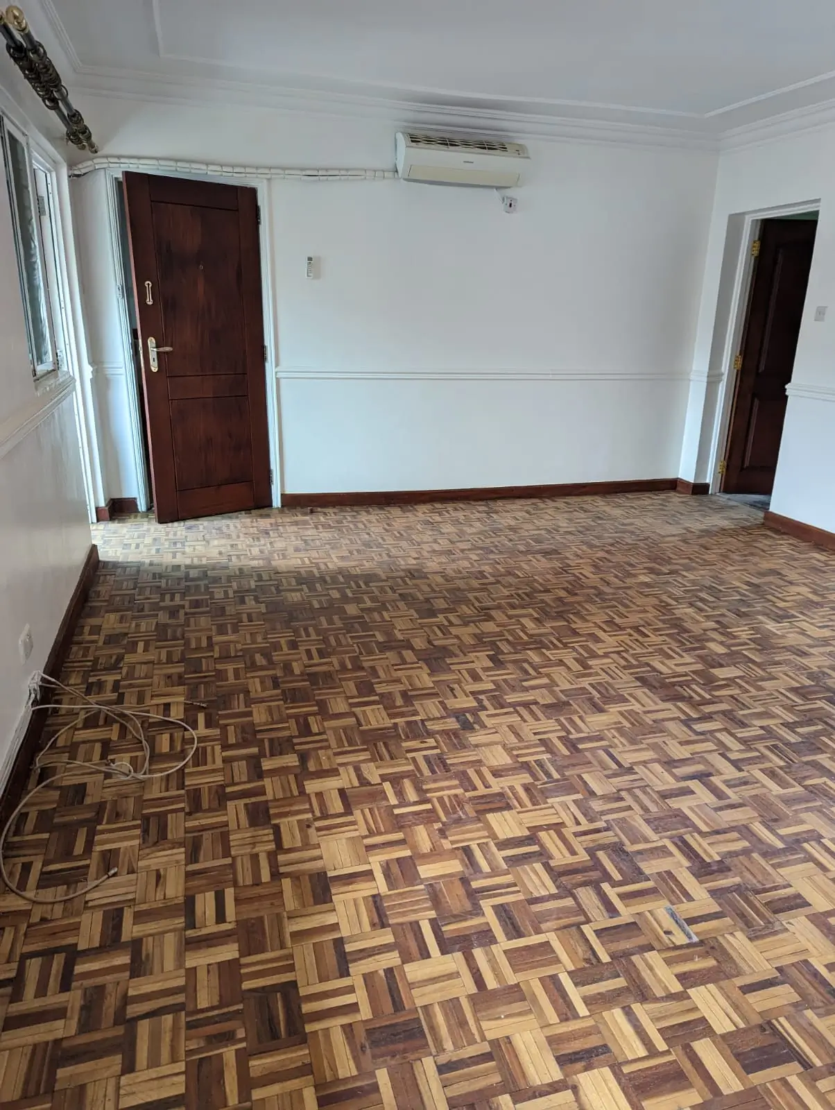 Spacious living room with parquet flooring and air conditioning