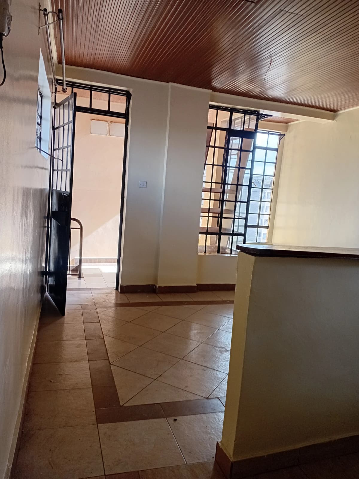 Open kitchen with counter, corrugated metal ceiling, tiled floor