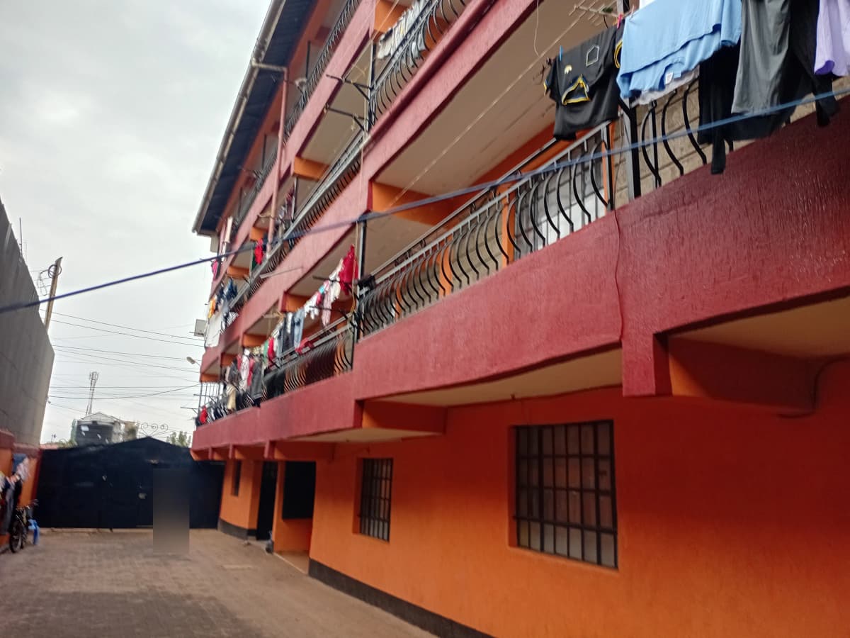 Red and orange residential building facade with balconies and clotheslines