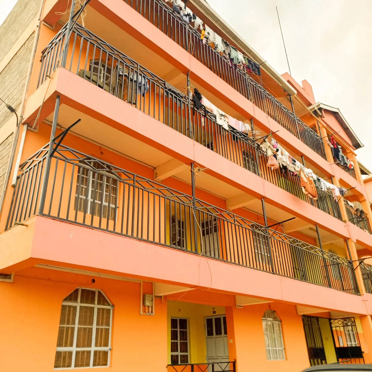 Bright orange multi-story residential building facade with balconies