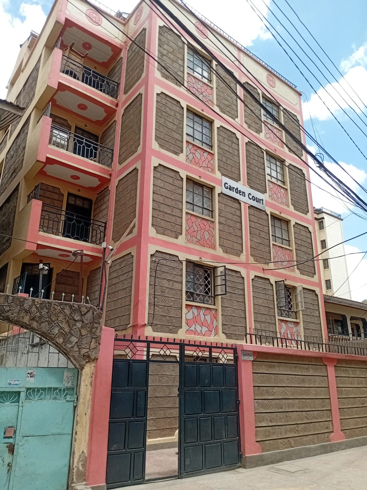 Pink and stone multi-story residential building facade with balconies