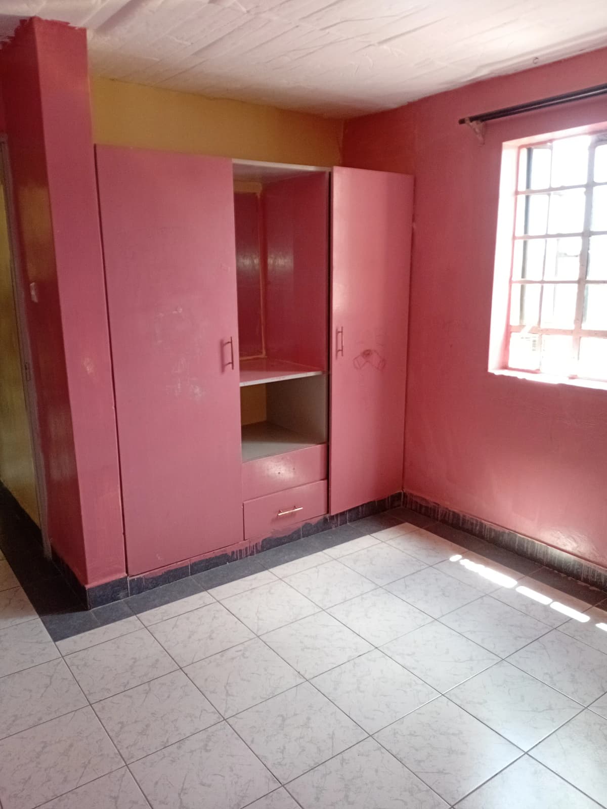 Bedroom with pink built-in wardrobe and window