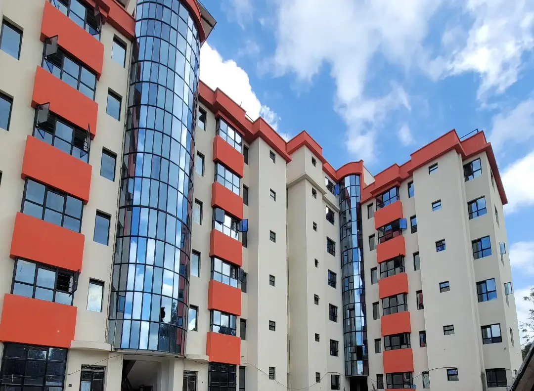 Modern multi-story residential building with red and cream facade