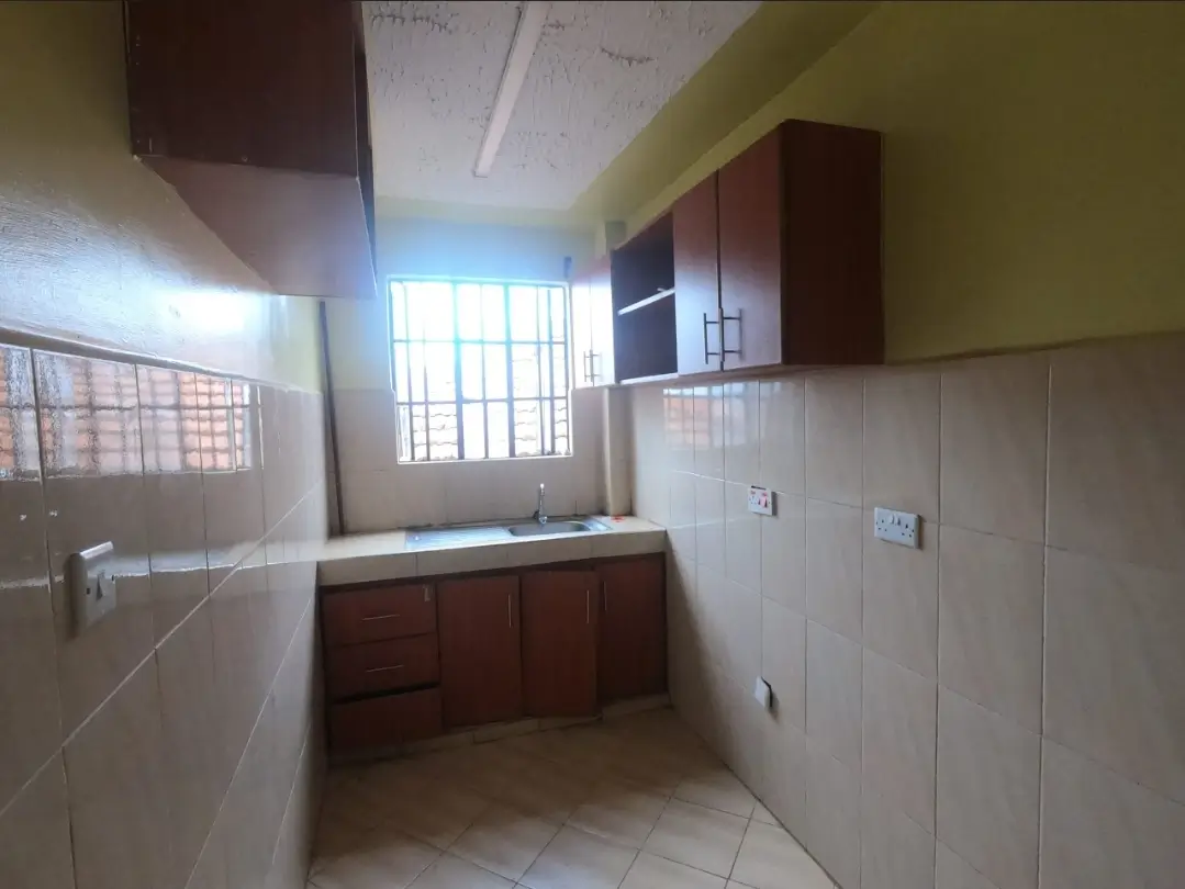 Compact kitchen with dark wood cabinets and tiled walls