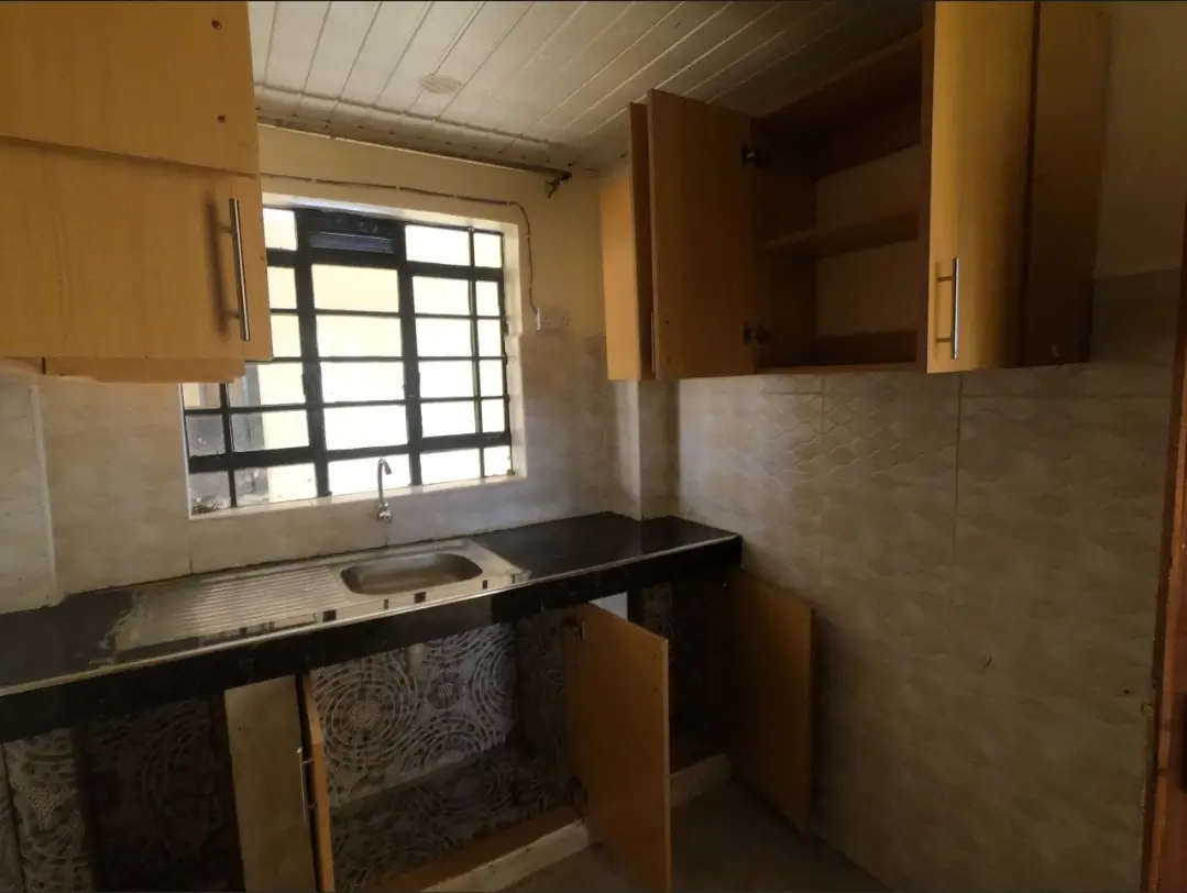 Compact kitchen with black countertop and single stovetop
