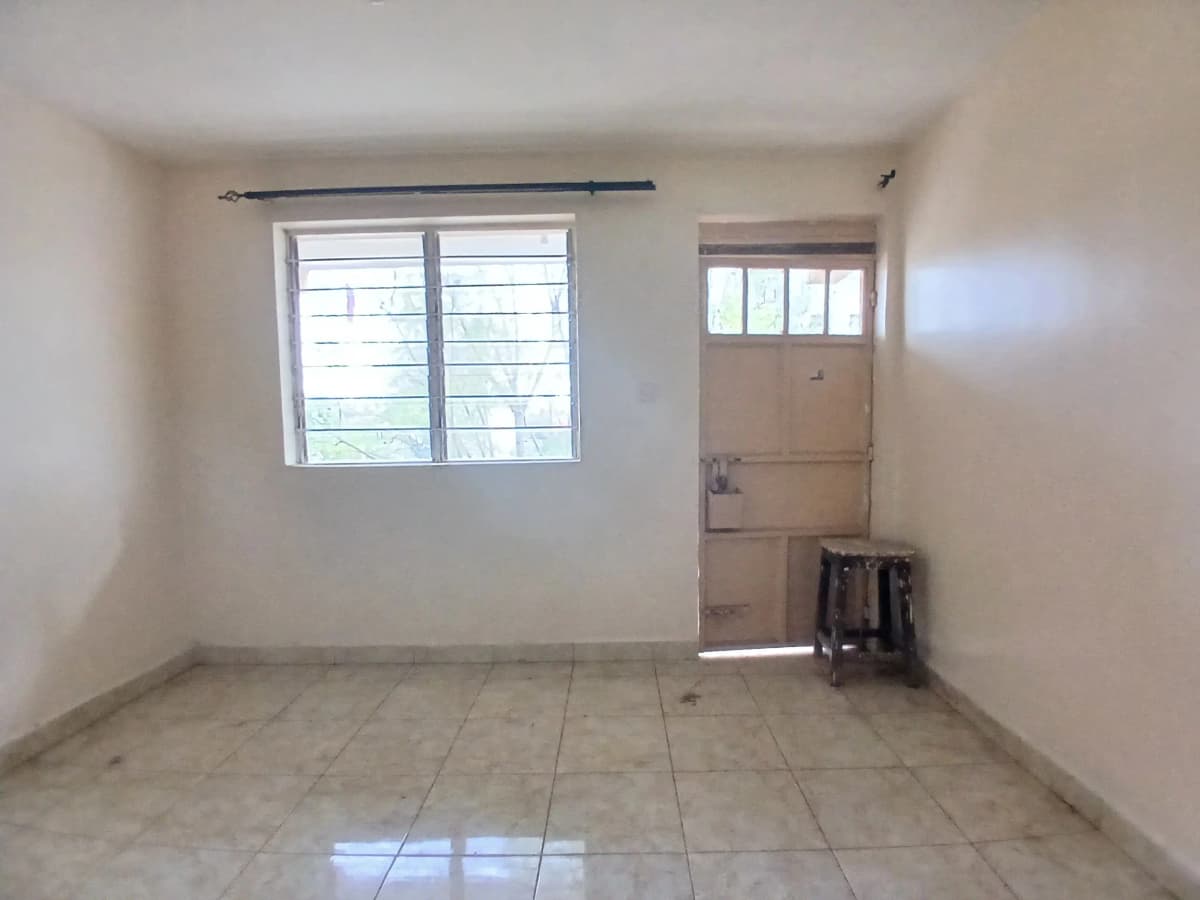 Empty living room with tiled floor and barred windows