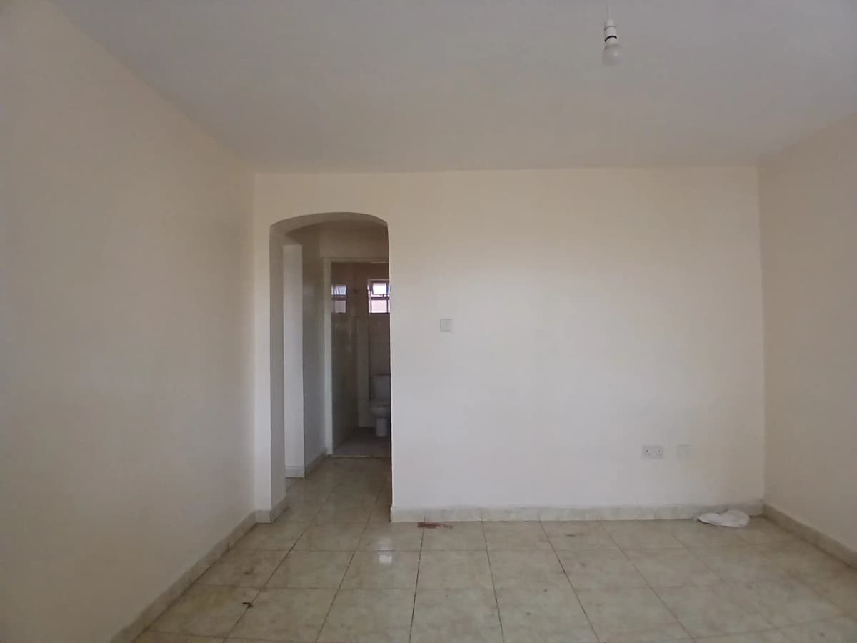 Empty living room with neutral walls and tiled flooring