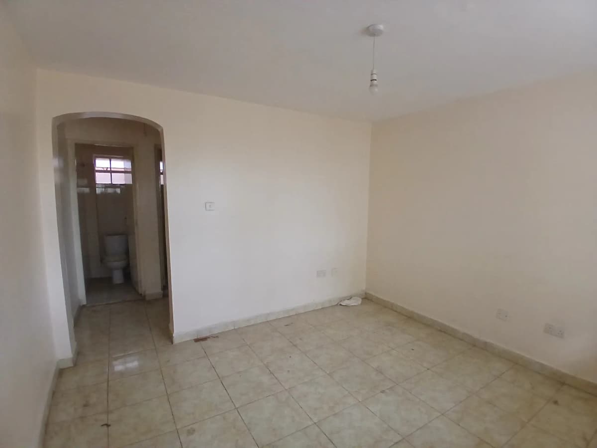 Empty living room with tiled floor and entry archway