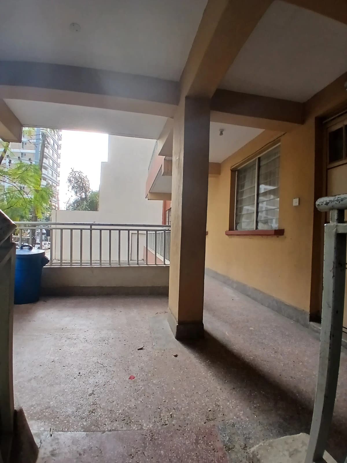 Open covered balcony with railing and city views
