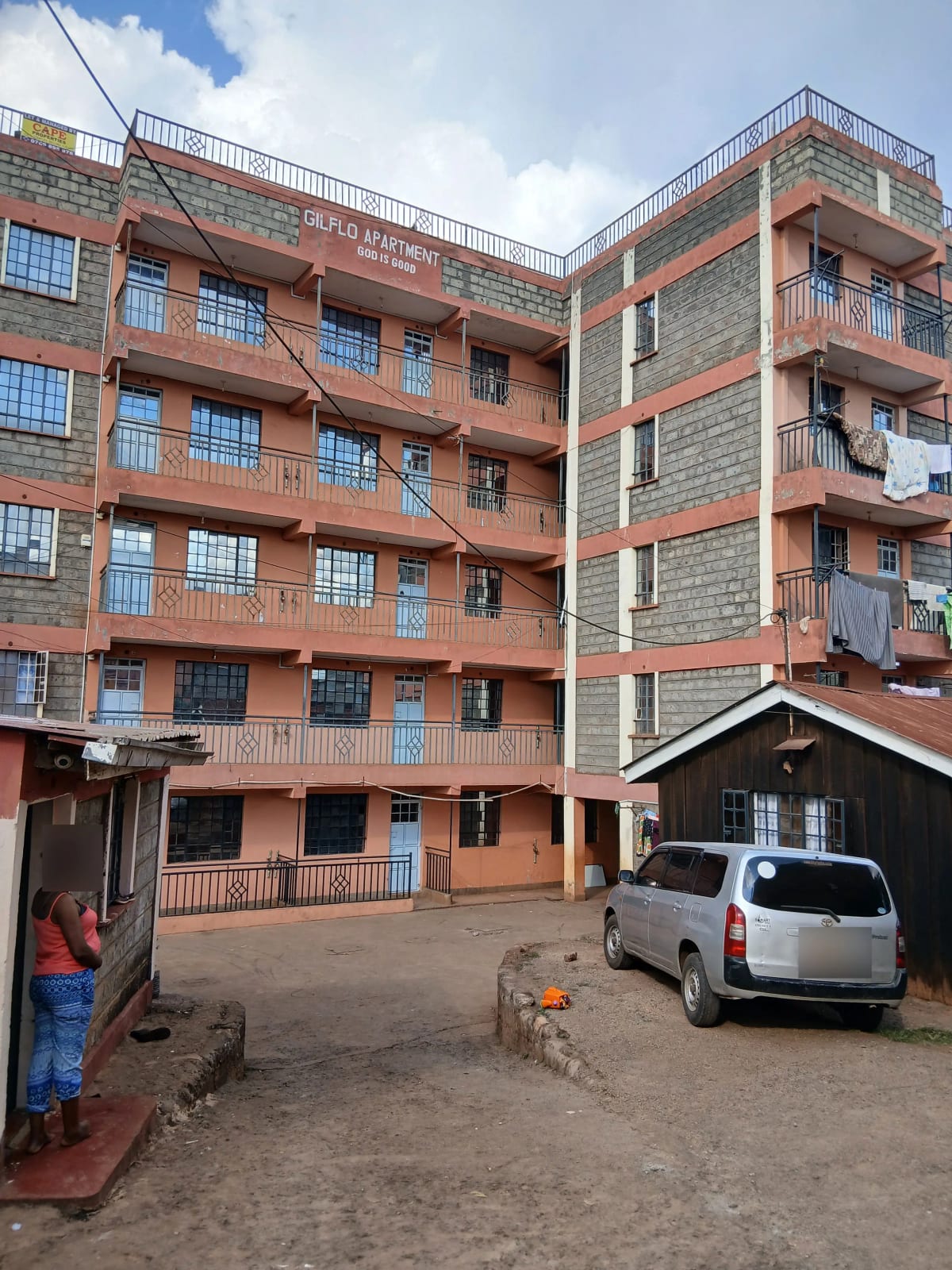 Multi-story residential building with ground-level parking compound