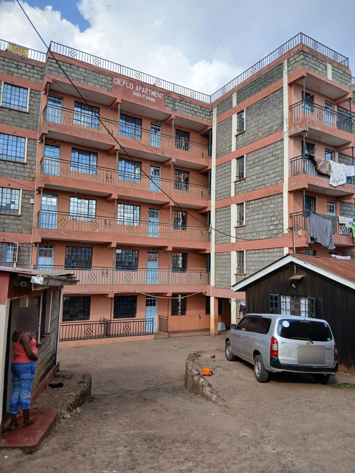 Multi-story residential building with ground-level parking compound