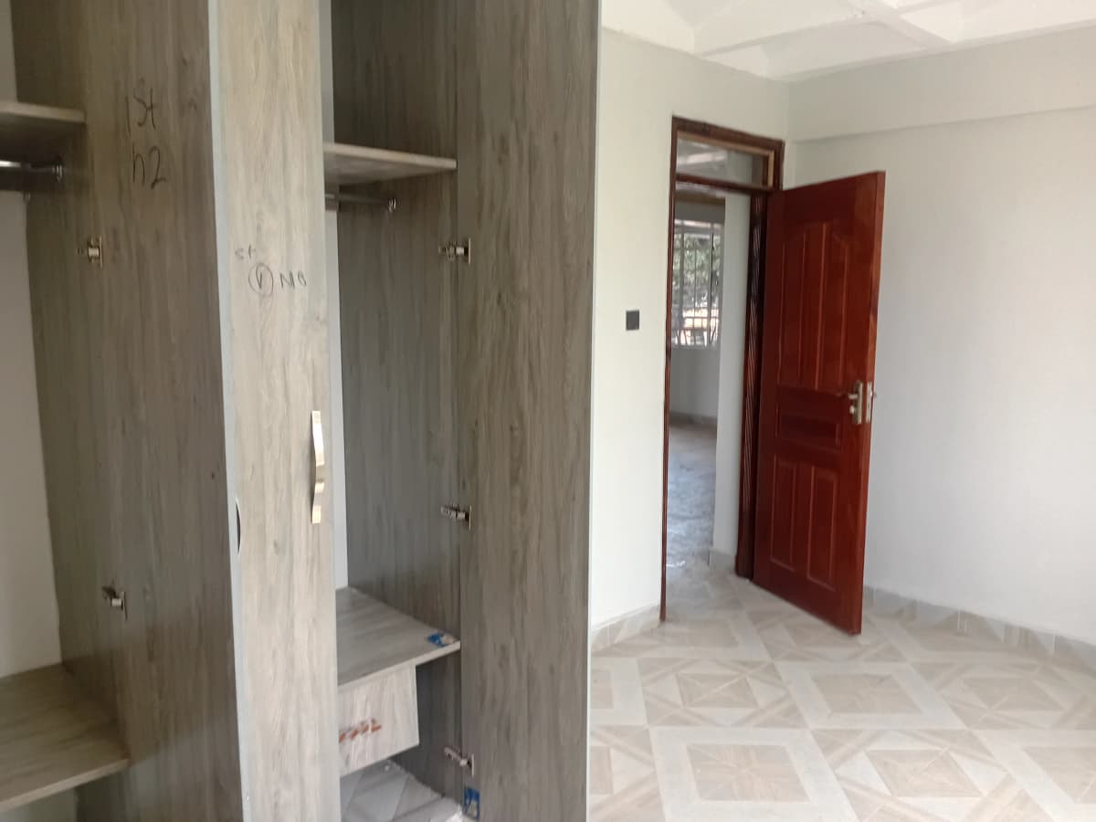 Bedroom with built-in wardrobe and red entrance door