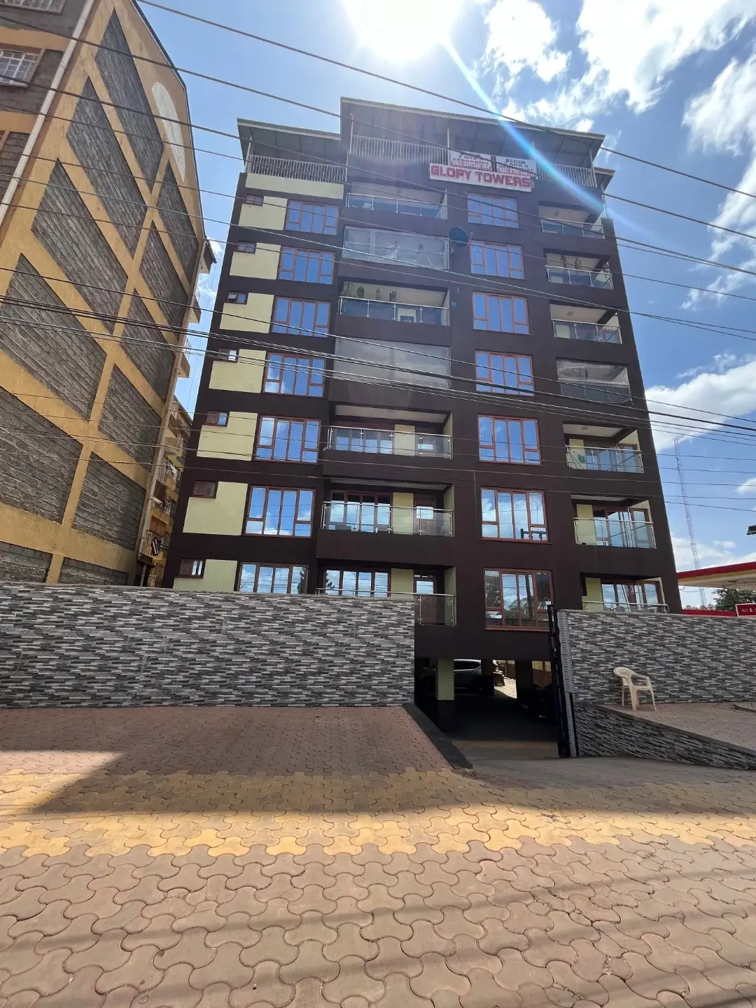 Modern multi-story residential building with stone facade entrance