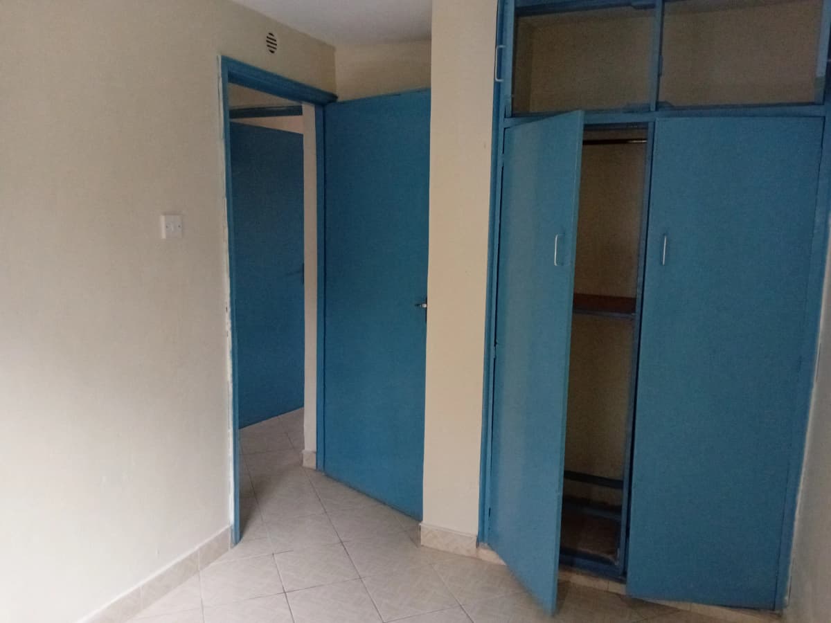 Unfurnished bedroom with blue wardrobe doors and entrance