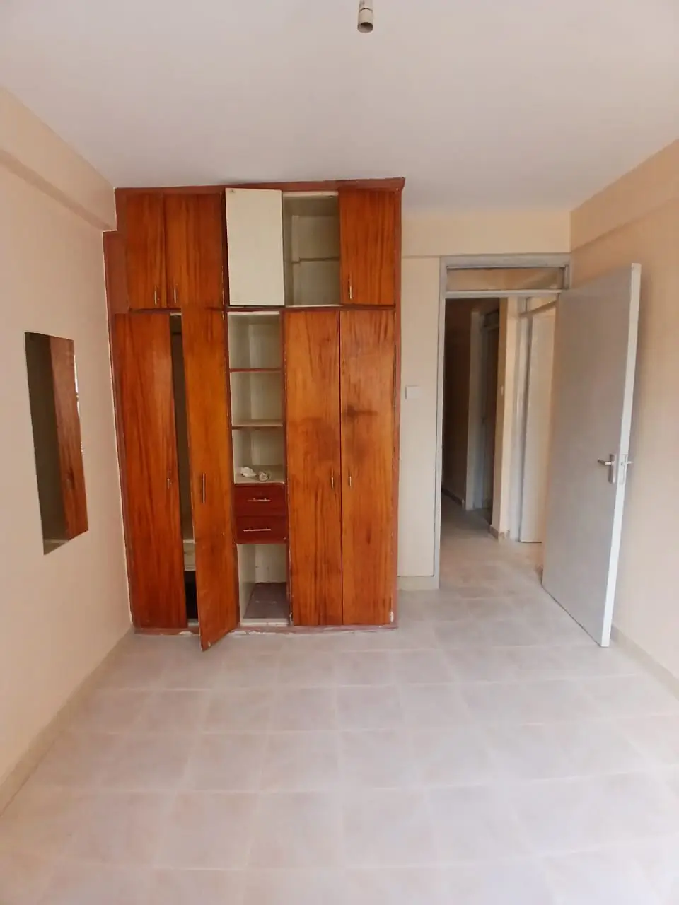Spacious bedroom with built-in wooden wardrobes and storage