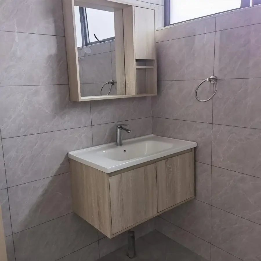 Modern bathroom with gray tiles, floating vanity, mirror cabinet