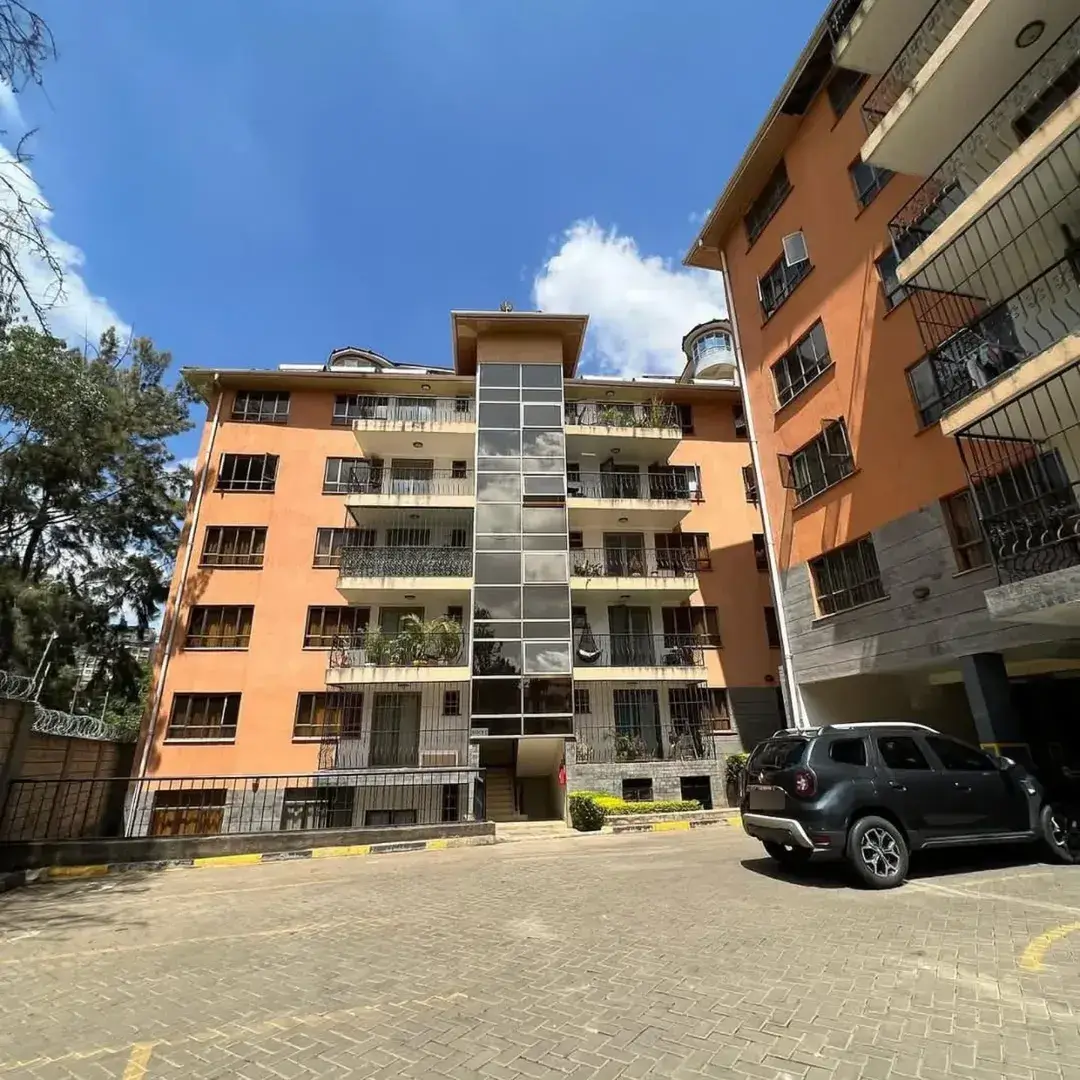 Orange residential building facade with ground-level parking bay