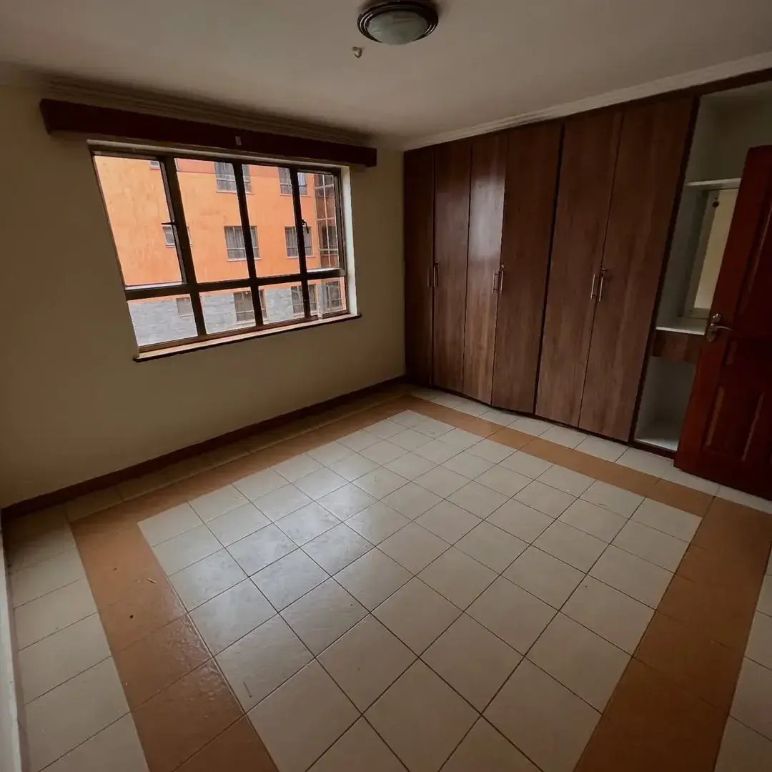Spacious bedroom with large window and built-in wardrobes