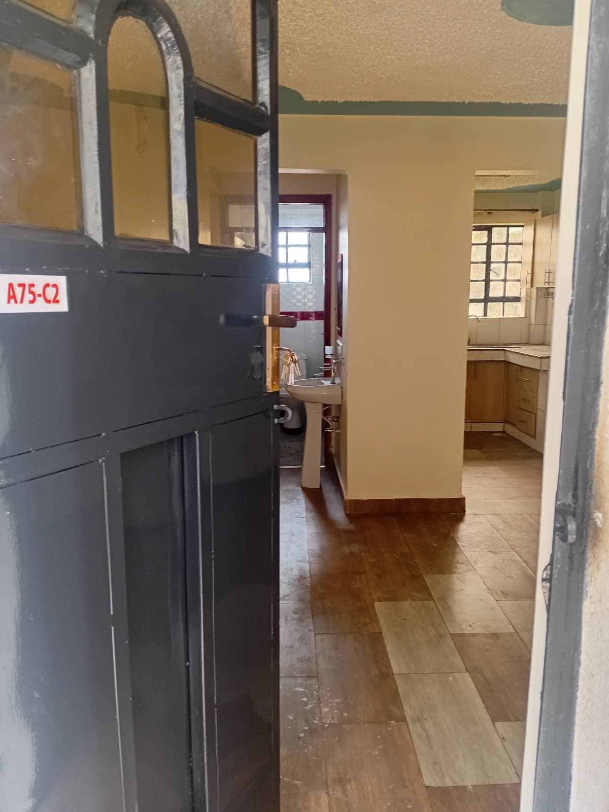 Building corridor with black door and tiled flooring