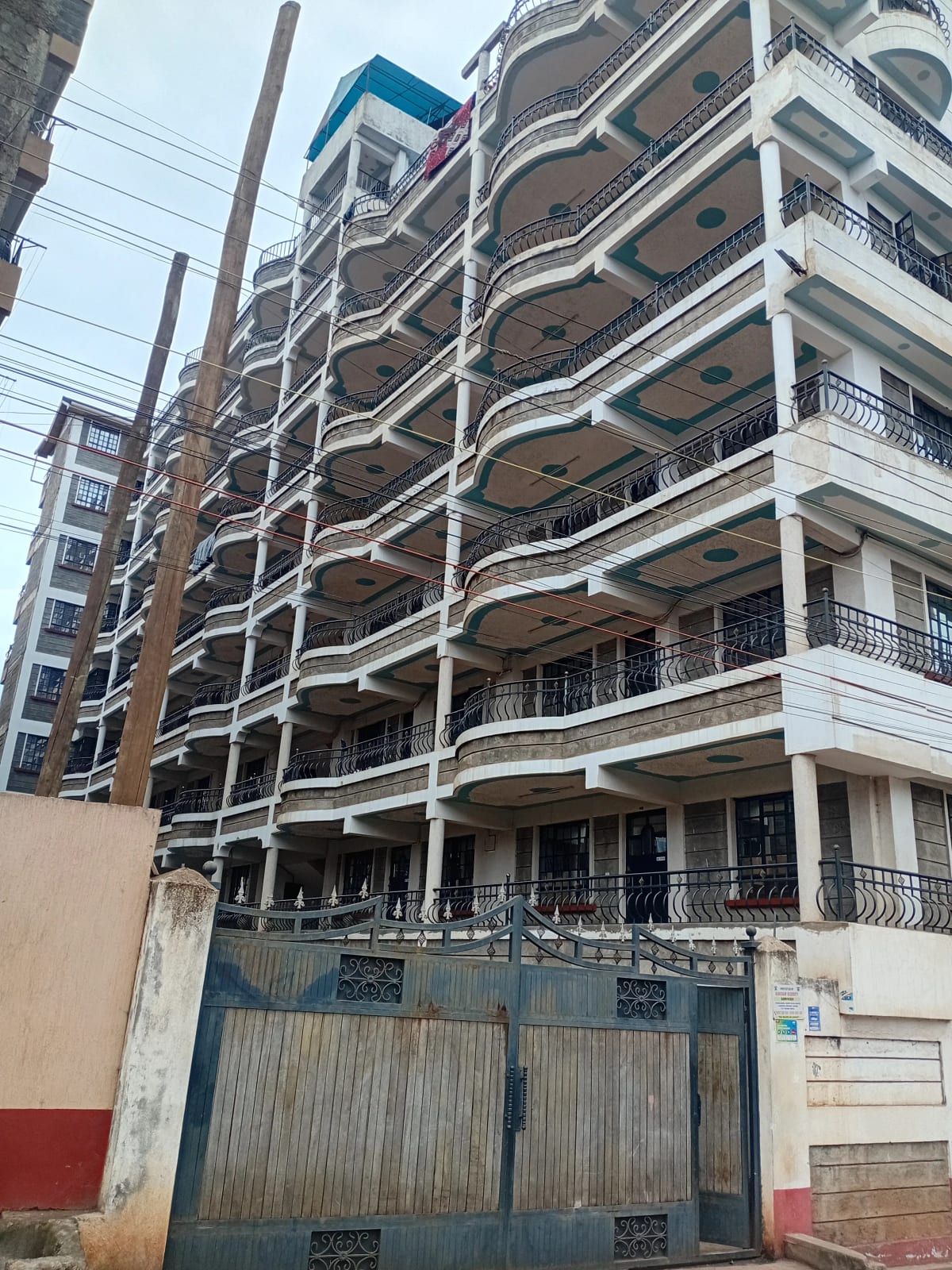Multi-story residential building facade with balconies and gate