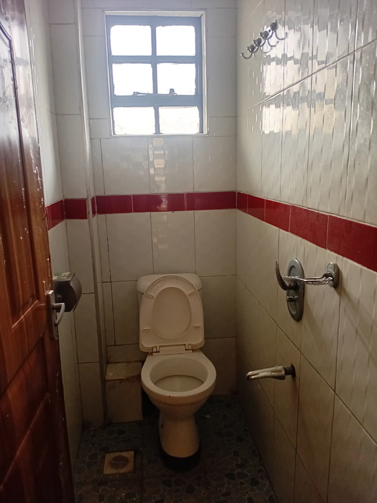 Compact bathroom with toilet, red and white tile design