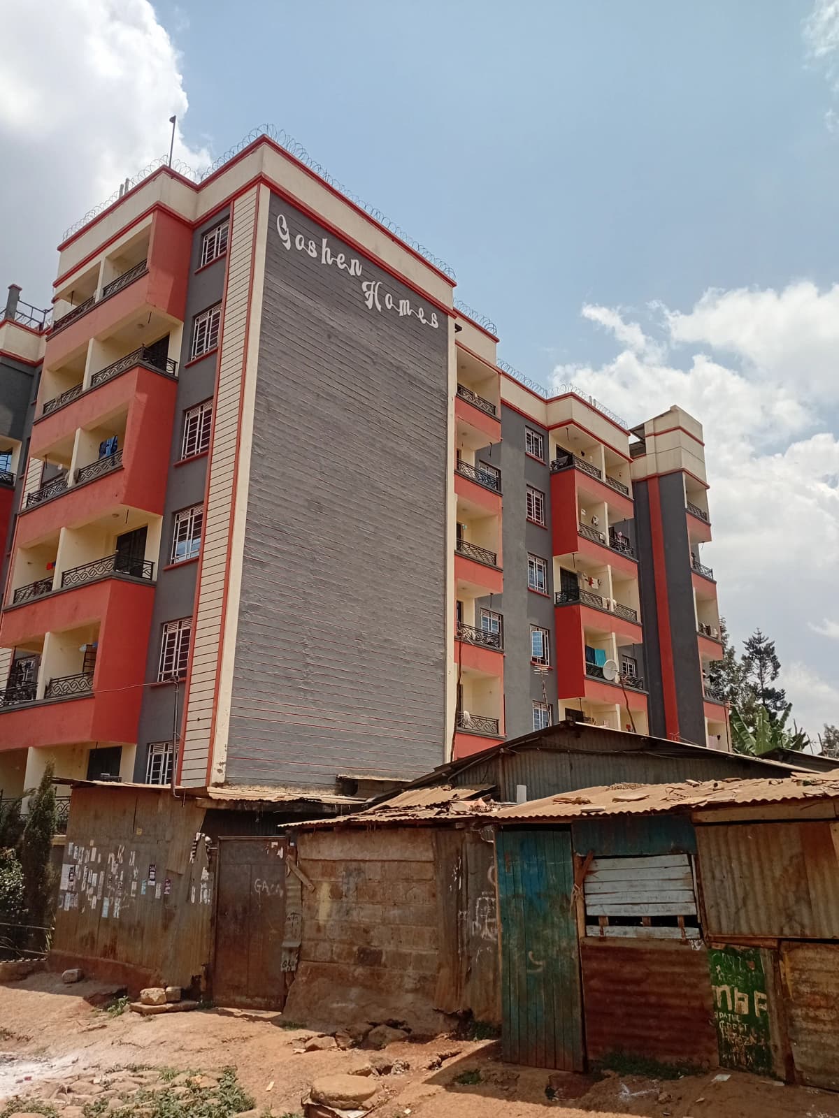 Red residential apartment building with ground-level structures
