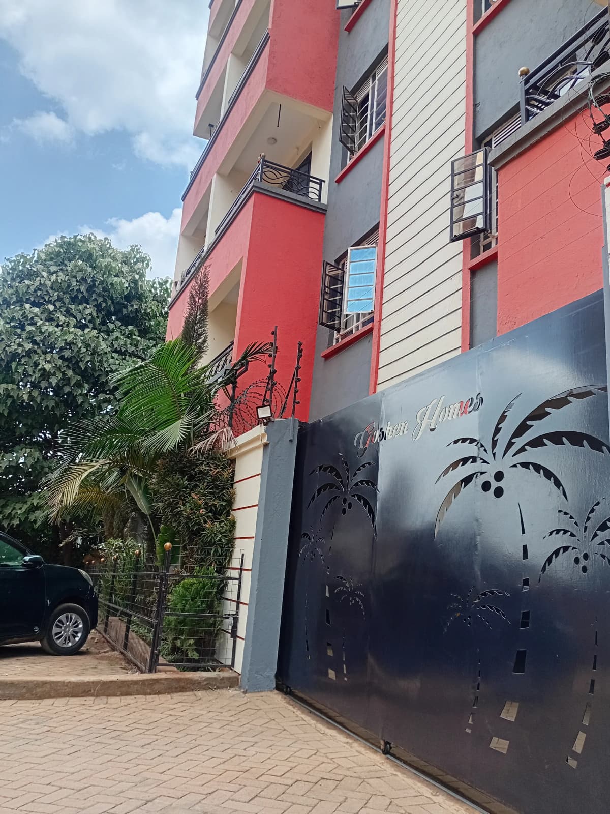 Modern red and white apartment building facade with gate entrance