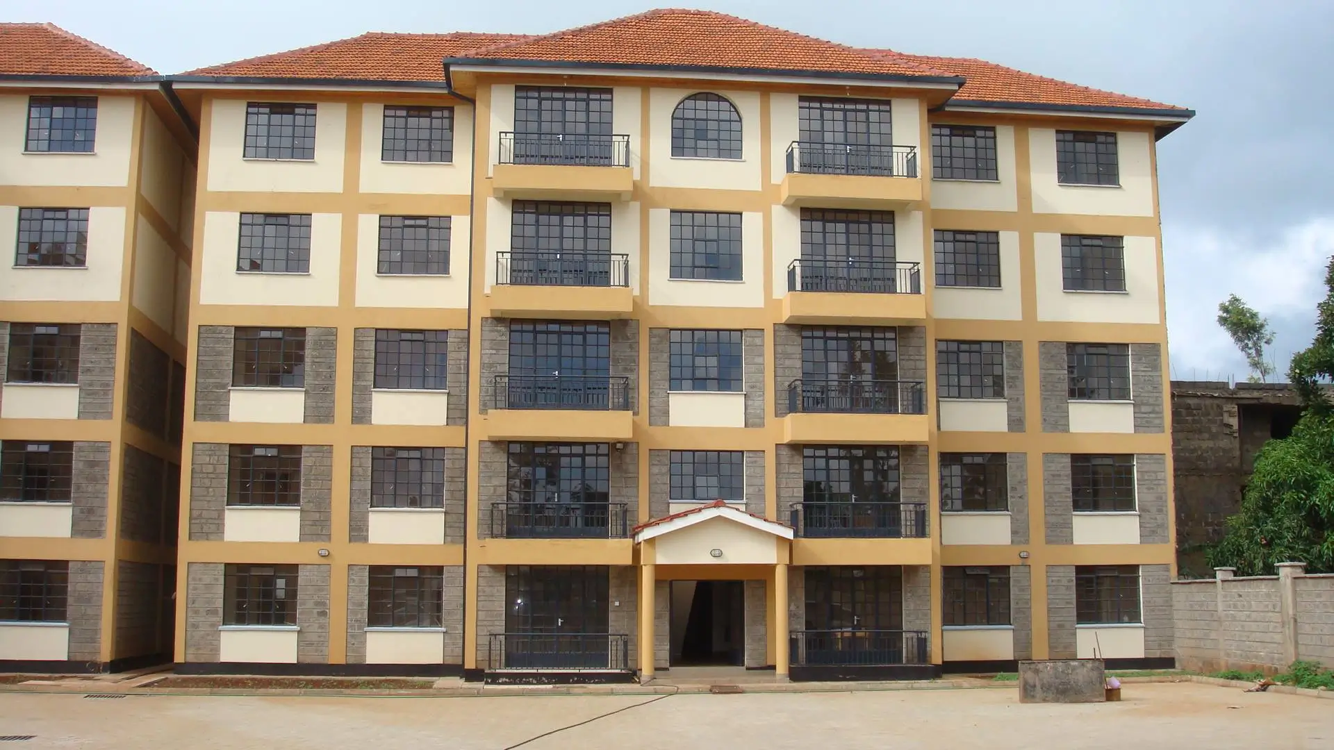 Multi-story residential building facade with yellow and cream exterior