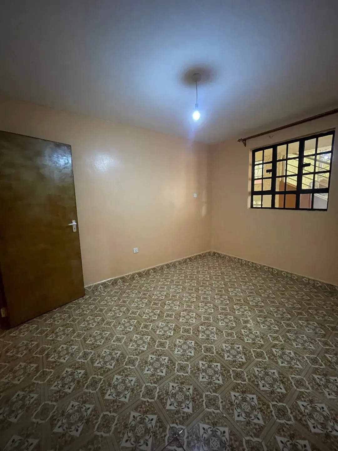 Empty bedroom with patterned tile flooring and window