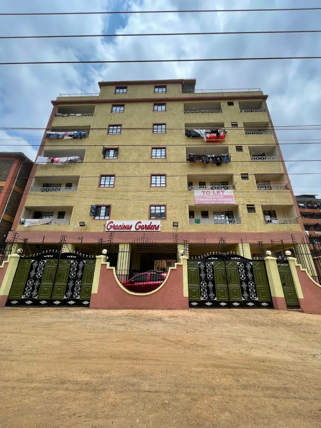 Multi-story residential building facade with balconies and ground-floor retail
