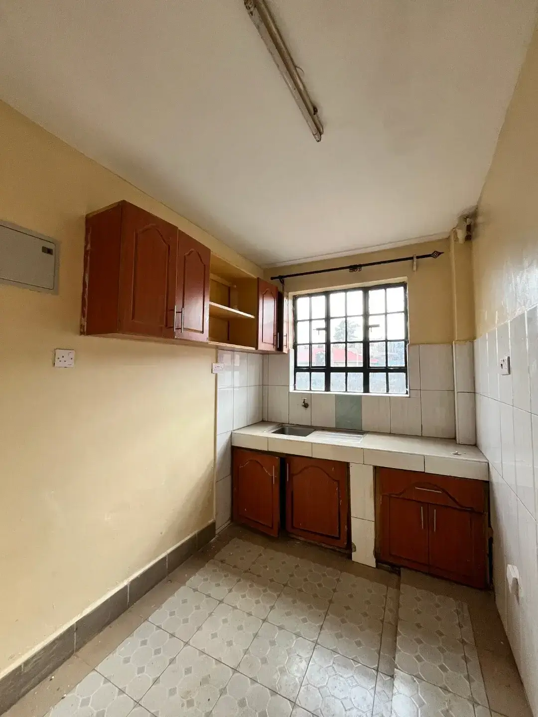 Compact kitchen with wooden cabinetry and tiled countertop