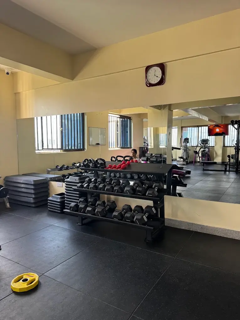 Well-equipped gym with dumbbell rack and wall mirrors