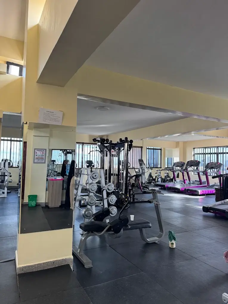 Spacious gym with cable machine and pink treadmills
