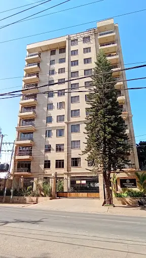 Multi-story residential building facade with balconies and landscaping