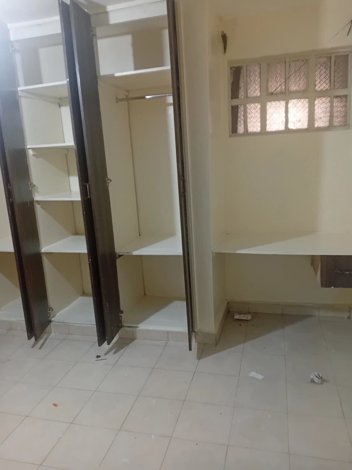 Empty bedroom with built-in wardrobe and window