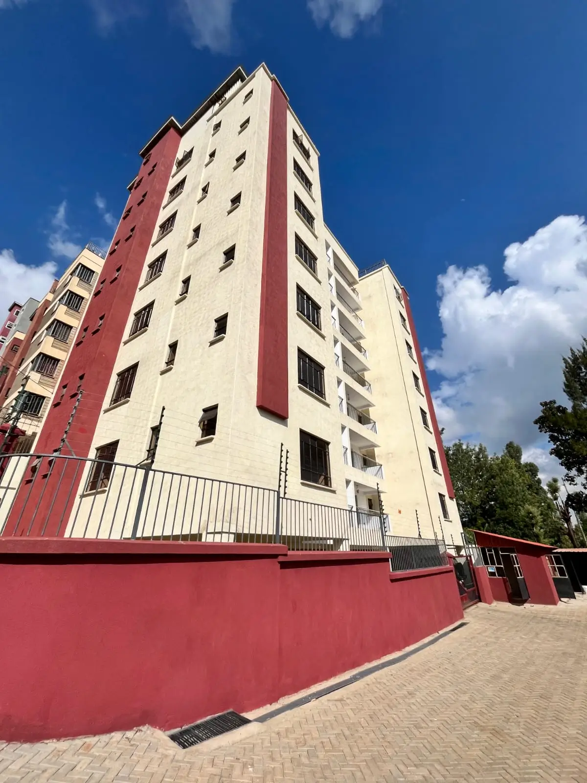 Multi-story residential building with red and cream facade