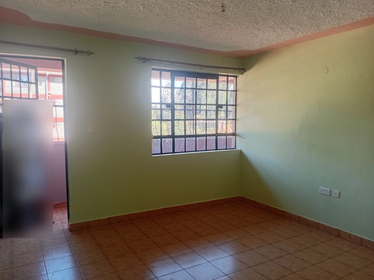 Unfurnished bedroom with natural light from barred windows