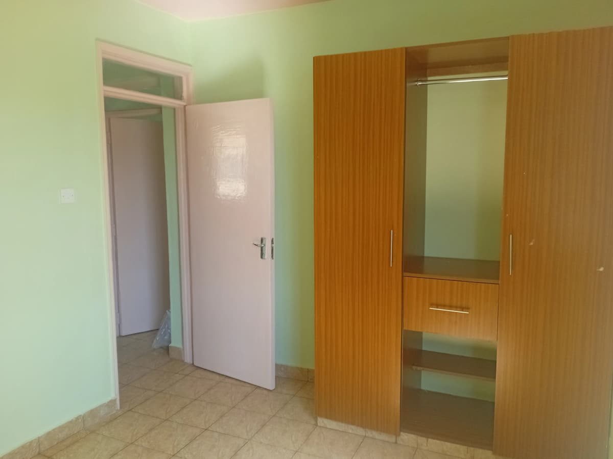 Bedroom with wooden wardrobe and entry door