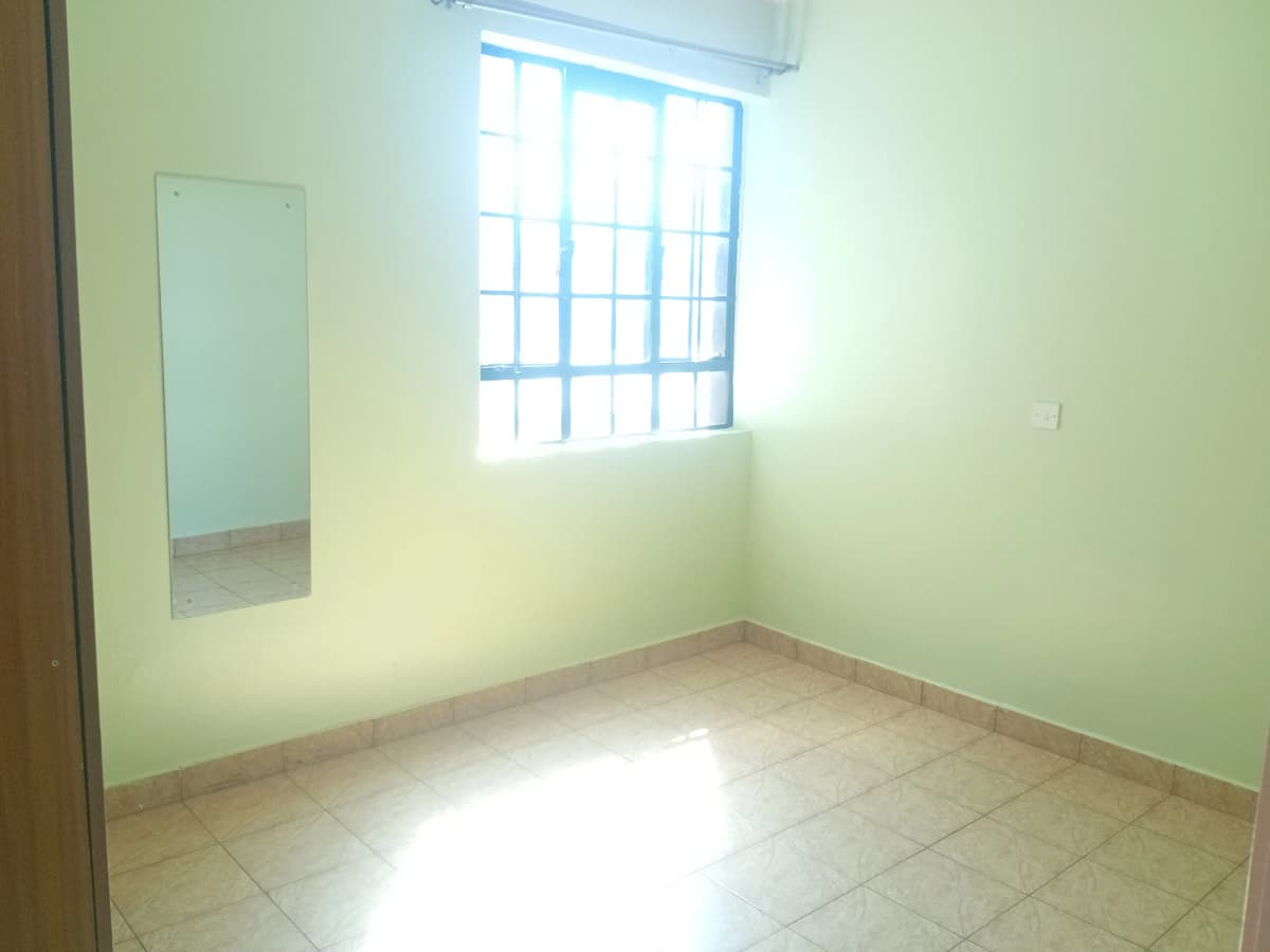 Bright bedroom with barred window and tiled flooring